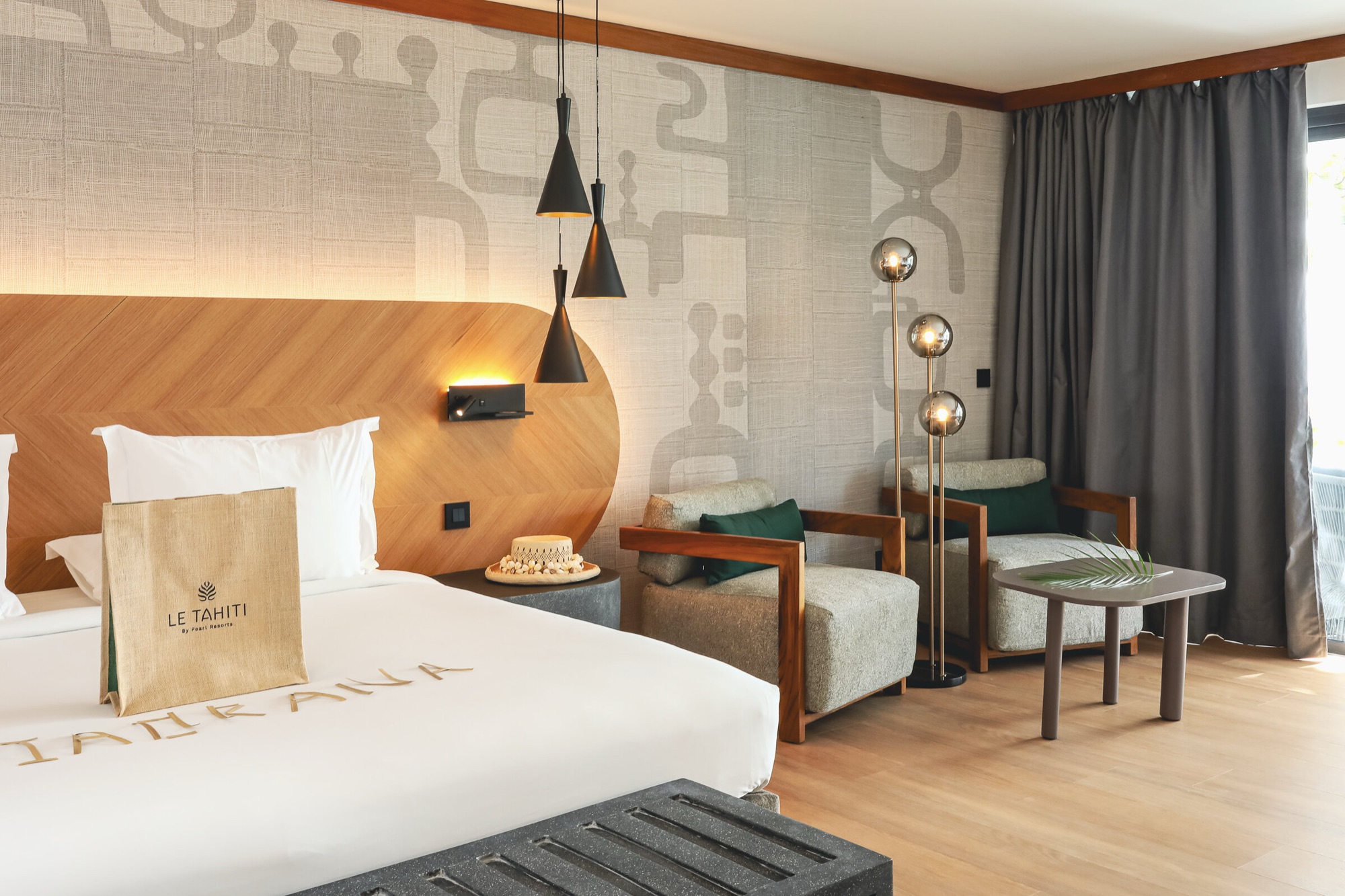 Hôtel Le Tahiti, Arue — suite : tête de lit en bois à chevrons, fauteuils en teck et lampadaires à globes
