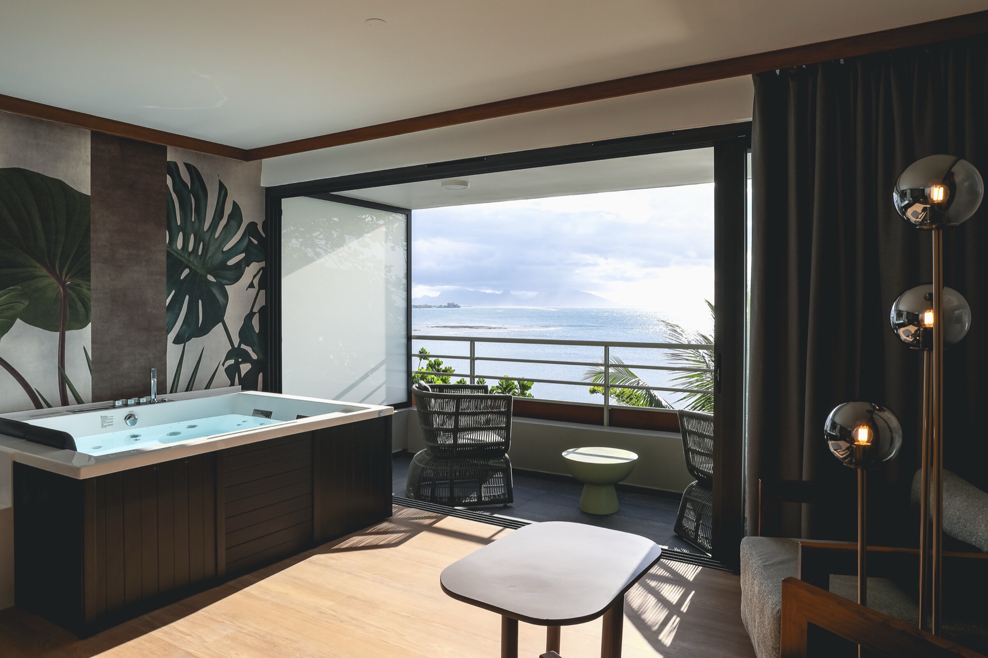 Hôtel Le Tahiti, Arue — suite : baignoire spa devant le mur de feuilles, terrasse ouverte sur le lagon