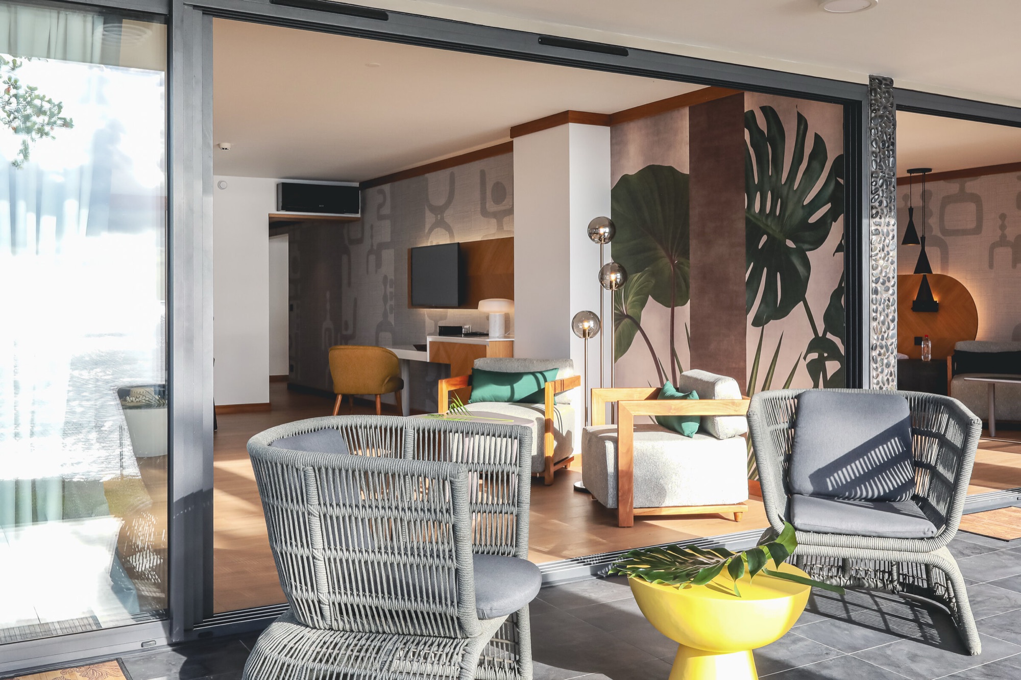 Hôtel Le Tahiti, Arue — suite : salon vu depuis la terrasse, fauteuils en corde tressée et guéridon jaune