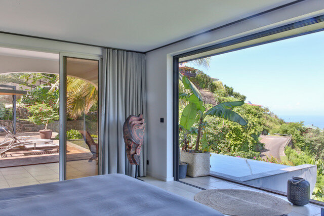 Maison particulière — chambre ouverte sur la terrasse et les bananiers, vue sur l'océan